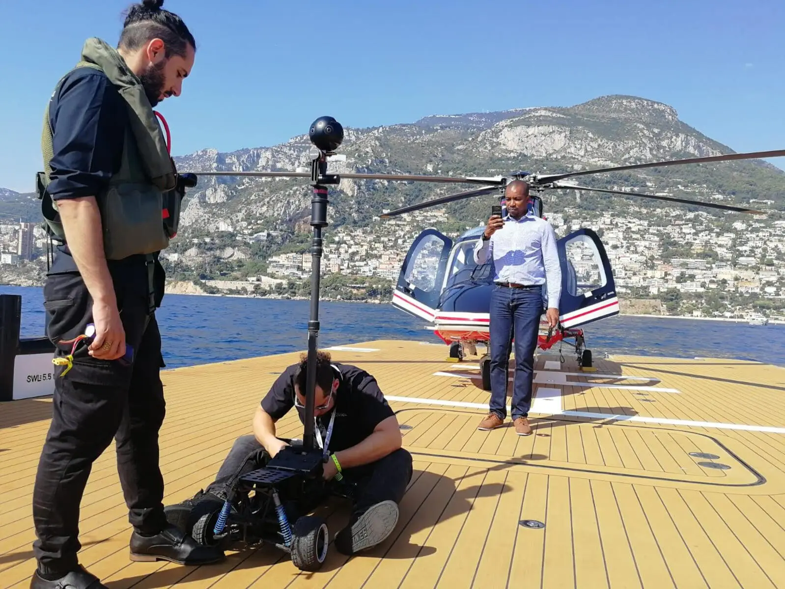 A 360 camera rig on a helicopter pad at the Monaco Yacht Show, with the crew beside it